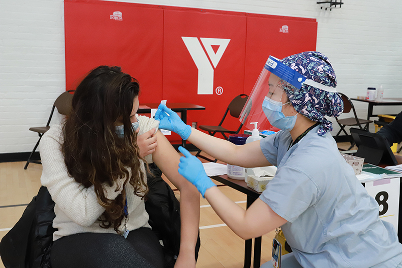 A woman gets her vaccine at a YMCA clinic